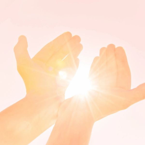 Hands reaching toward sunlight representing a holistic approach to mental health therapy